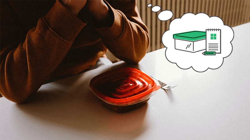 A geocacher sits at a table with a tupperware conainer on it and thinks of a tupperware geocache container.