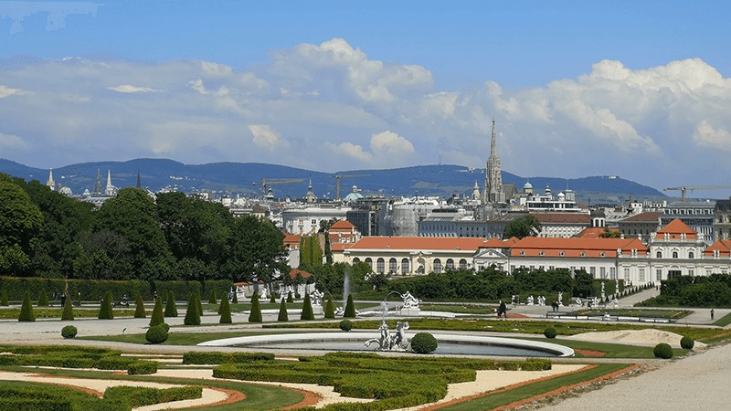 Ornate gardens and a view of the Vienna skyline.