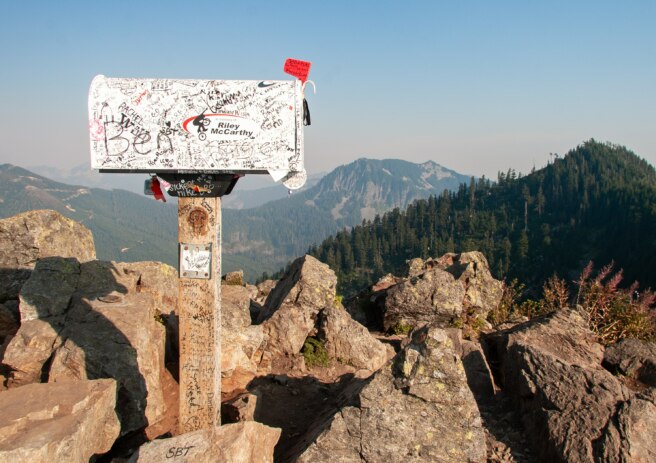 poštovní schránka na dřevěném sloupku s výhledem na pohoří